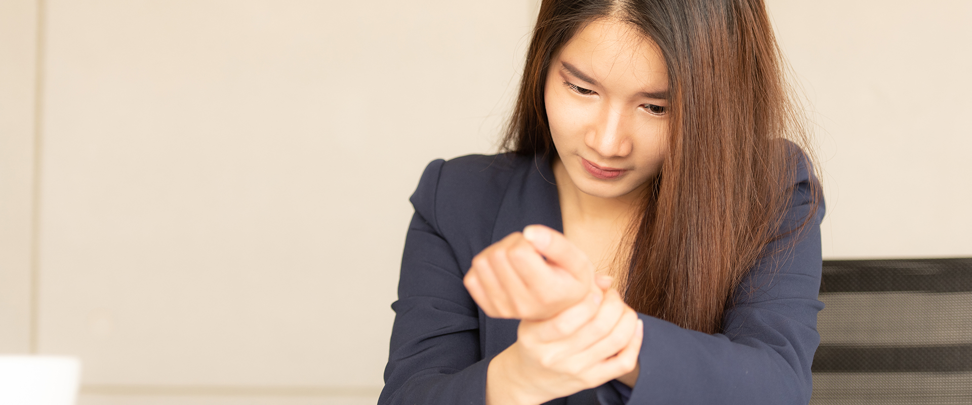 Frau betrachtet ihr schmerzendes Handgelenk