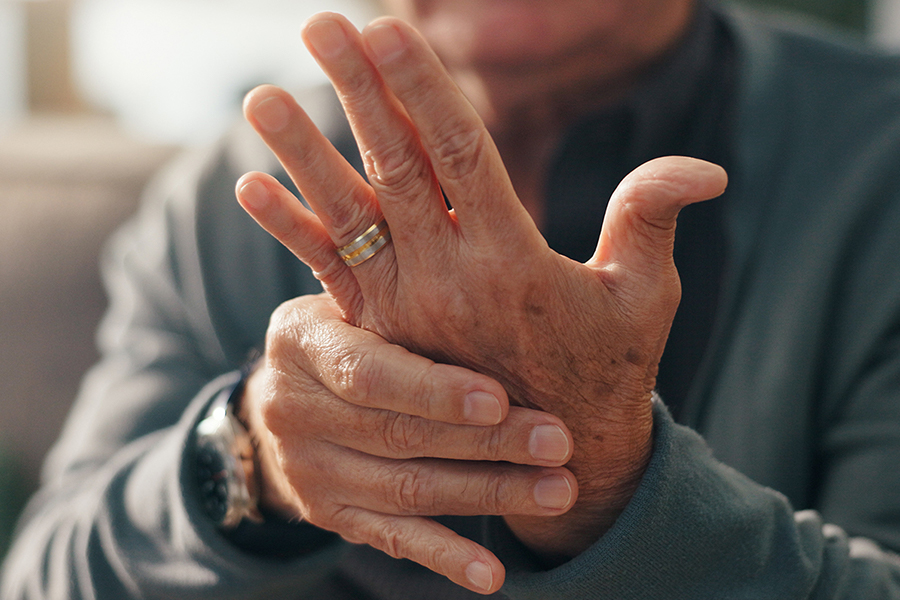 Älterer Mann hält seine schmerzende Hand fest