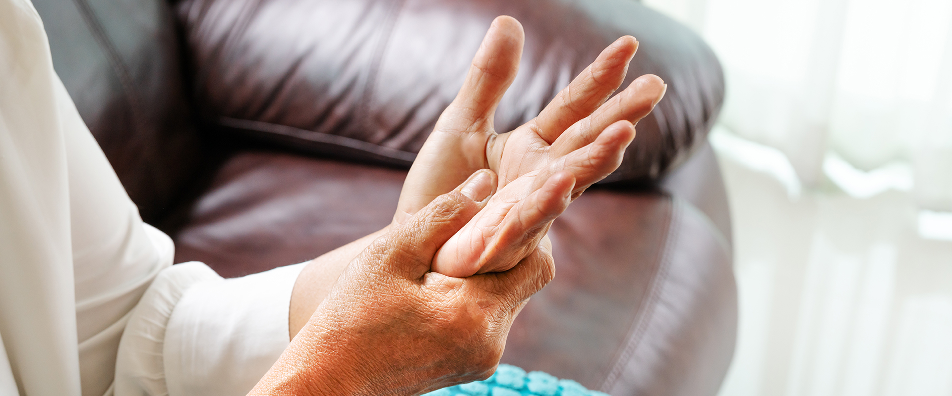 Ältere Frau hält ihre schmerzende Hand fest